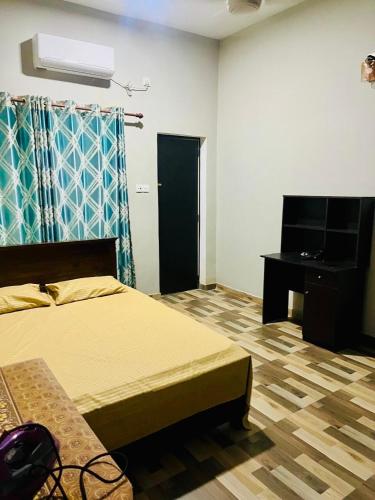 a bedroom with a bed and a desk and a television at Larmount Nest Two bedroom house in Ratmalana Mount Lavinia in Mount Lavinia