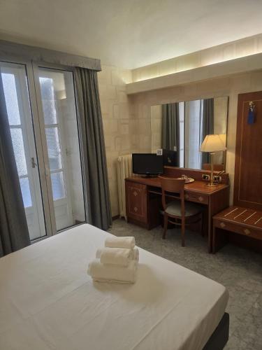 a hotel room with a bed and a desk at Hotel Chelsea in Turin
