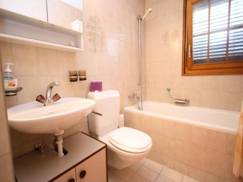 a bathroom with a toilet and a sink and a tub at Family Stay in Aletsch Alps in Bellwald