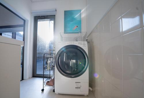 a washing machine in a room with a window at Encounter Dazaifu in Dazaifu