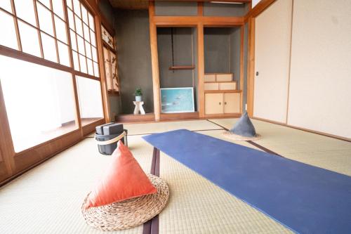 a room with a table and a blue rug at Encounter Dazaifu in Dazaifu