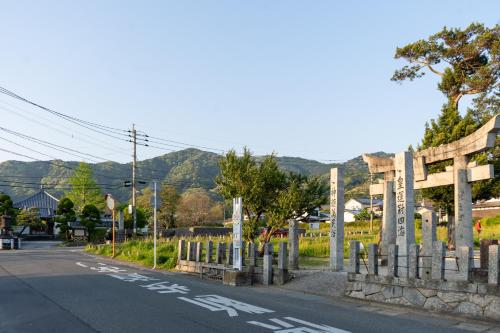 an empty street with a fence on the side of a road at Encounter Dazaifu in Dazaifu