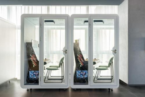 two glass doors with chairs in a room at Pagoda Hotel Shenzhen Familytrip&BusinessTravel in Shenzhen