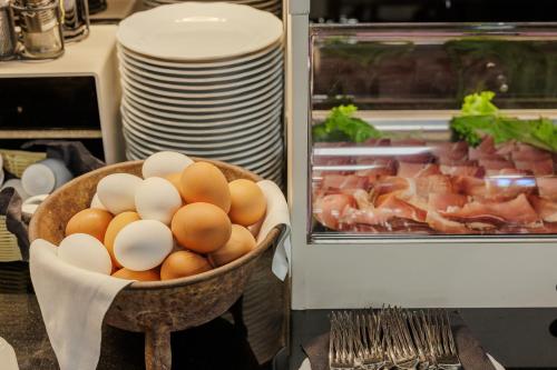 a basket of eggs and ham in a kitchen at Hotel San Marco in Bardolino