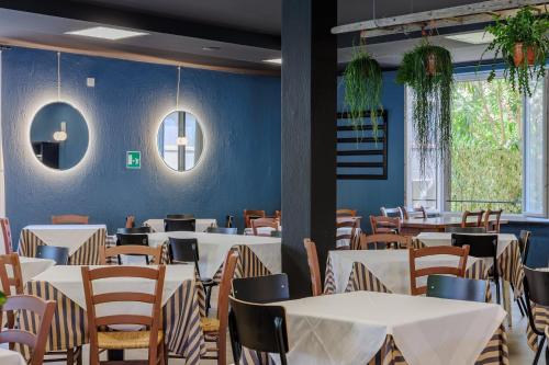 a dining room with white tables and chairs at Hotel San Marco in Bardolino