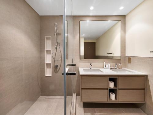 Un baño con ducha, lavabo y espejo. en Skyline View - 2 Balconies - Pool plus Gym - Sleeps 8, en Dubái