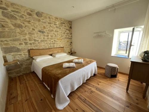 Un dormitorio con una cama y una pared de piedra. en LA BERGERIE, en Domessargues