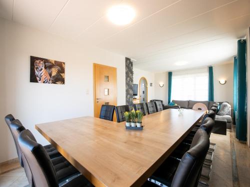a conference room with a large wooden table and chairs at Villa East Canton with Sauna in Nieder-Emmels