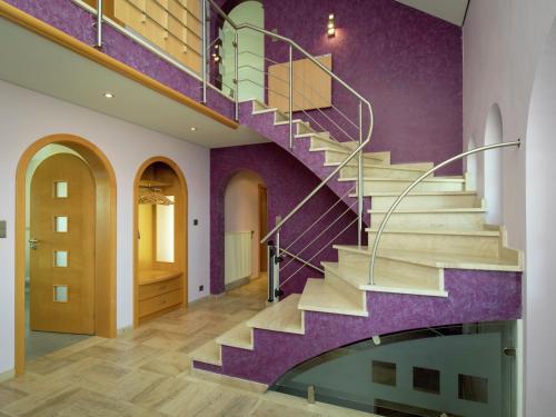 a staircase in a house with purple walls at Villa East Canton with Sauna in Nieder-Emmels