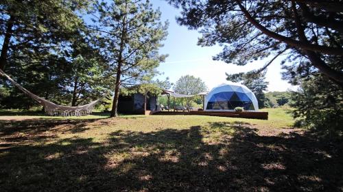 a tent in the middle of a field with trees at Merekalda Glämp 