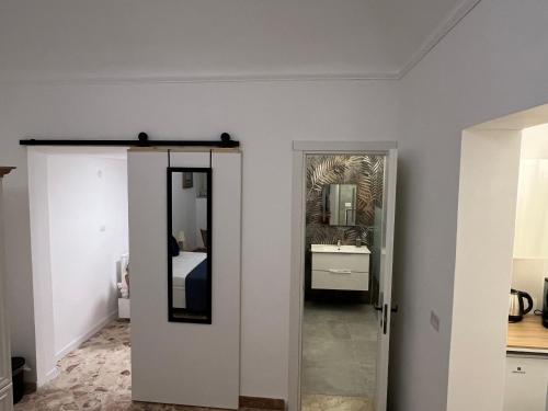 a hallway with a mirror and a bed in a room at Appartamenti Tiffany & Timi in Carini