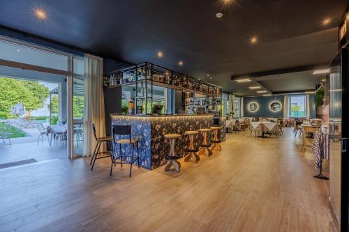 a restaurant with a bar with tables and chairs at Hotel San Marco in Bardolino