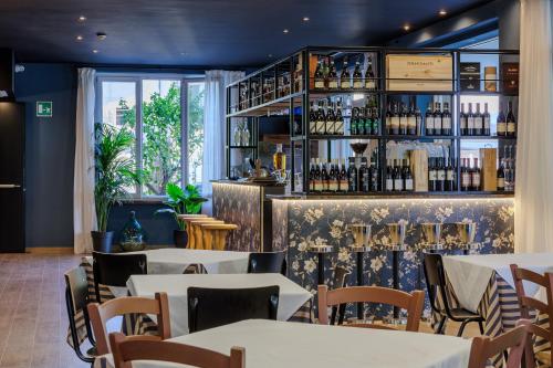 a restaurant with tables and chairs and a shelf with wine bottles at Hotel San Marco in Bardolino