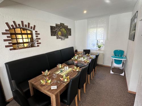 a dining room with a long table and chairs at Landhotel & Restaurant "Fahrenkamp" in Röwitz