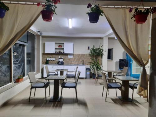 a dining room with tables and chairs and a kitchen at Casa Simone in Costinesti