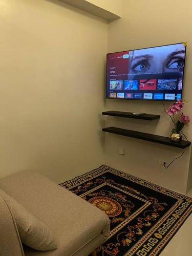 a room with a tv on the wall with a rug at Near Airport Casa Isabel Primeworld in Agus