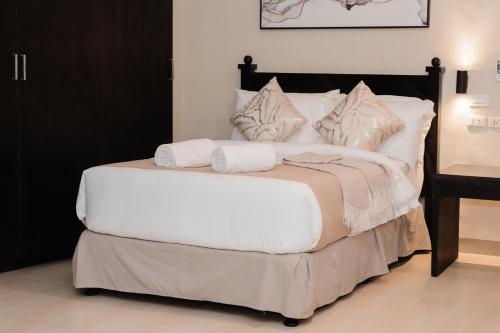 a bedroom with a bed with white sheets and pillows at The New View by Ecotel - Cebu in Cebu City