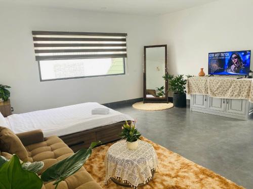 a room with a bed and a couch and a mirror at LALA HOUSE - CĂN HỘ Đà Lạt in Khu Chi Lăng