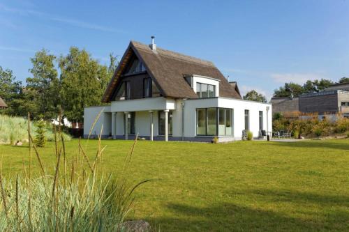 ein Haus mit einem grünen Rasen davor in der Unterkunft Kapitänsweg 17 in Ostseebad Karlshagen