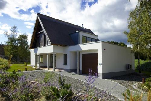 ein weißes Haus mit einem schwarzen Dach in der Unterkunft Kapitänsweg 17 in Ostseebad Karlshagen