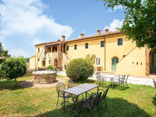 a group of tables and chairs in front of a building at Appealing Apartment in Collesalvetti with Garden in Nugola