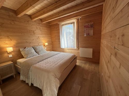 a bedroom with a bed in a wooden cabin at Chalet les Buffettes - 4P8 in Saint-Jean-dʼArves