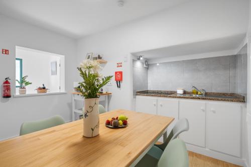 a kitchen with a wooden table with a bowl of fruit on it at Luzia by the Sea - T1 Acolhedor a Passos da Praia in Calheta