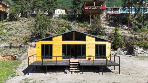 メスティアにあるTetnuldi River Chaletの丘の上に小さな家が建てられている