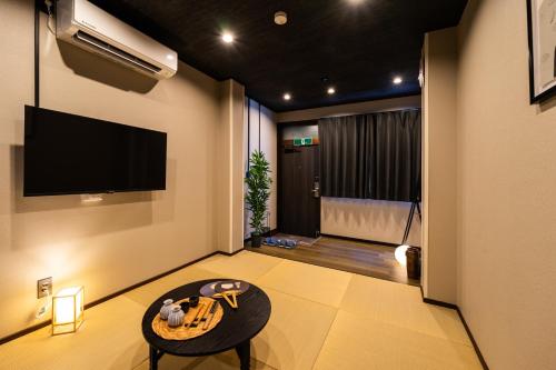 a living room with a tv and a table at おやど紀伊国屋大黒町通 in Nagasaki