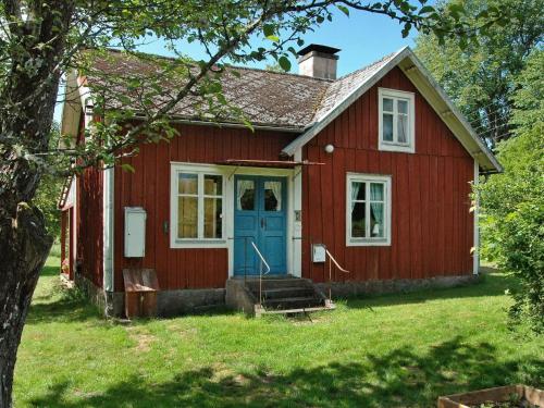 a red house with a blue door at 5 person holiday home in KALVSVIK in Kalvsvik
