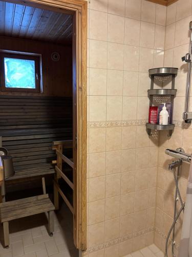 a bathroom with a shower with a bench and a window at Harmonia in Keminmaa