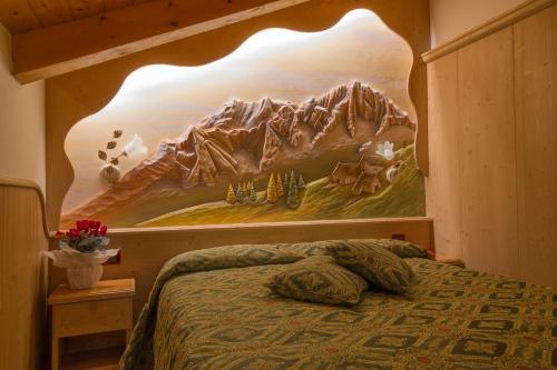 a bedroom with a bed with a mountain mural on the wall at Hotel Orchidea in Passo del Tonale
