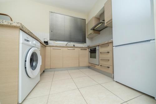 a kitchen with a washing machine and a refrigerator at Modern 2 bedroom flat in Engomi in Strovolos