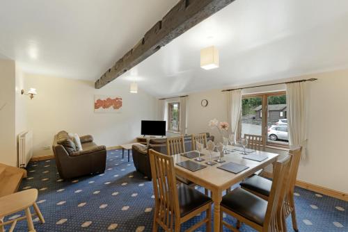 a dining room with a table and chairs and a living room at Bank View Barn at Pound Farm in Crook