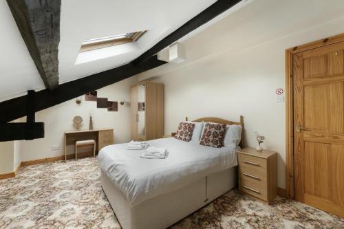a bedroom with a bed and a desk in it at Bank View Barn at Pound Farm in Crook