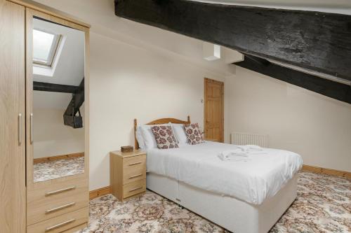 a bedroom with a white bed and a mirror at Bank View Barn at Pound Farm in Crook