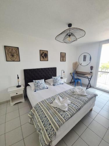 a bedroom with a large bed and a chandelier at Charmant T2 avec grande terrasse in Saint-Nazaire