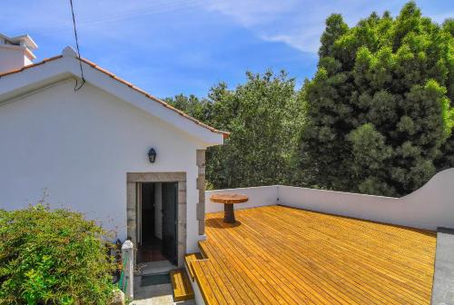 a deck with a table on top of a house at Moinho do Prado in Vila Nova de Cerveira