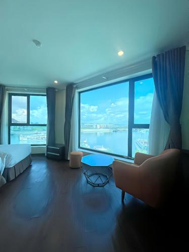 a large room with a large window with a bed and a couch at Pearl Hotel Tuan Chau - Ha Long in Ha Long