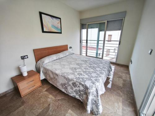 a bedroom with a bed and a dresser and a window at Adosado cerca del mar con piscina privada in Vinaròs