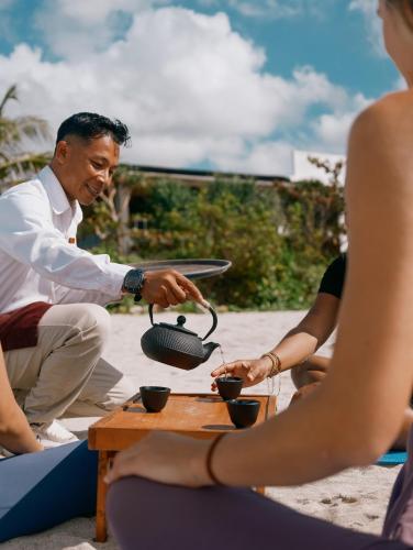 a group of people sitting around a table at Amber Lombok Beach Resort in Selong Belanak