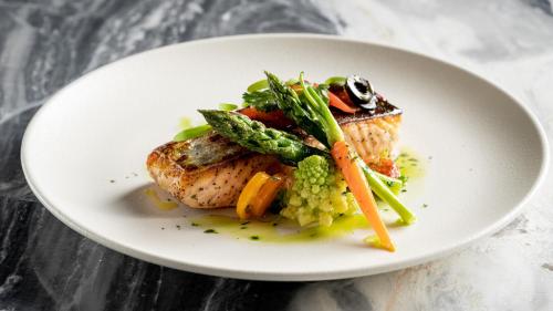 a plate of food with meat and vegetables on a table at Crowne Plaza Hangzhou Riverside by IHG in Hangzhou