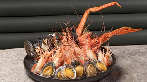 a bowl filled with shrimp and mussels on a table at Crowne Plaza Hangzhou Riverside by IHG in Hangzhou