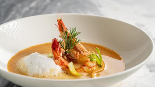 a white bowl of soup with seafood in it at Crowne Plaza Hangzhou Riverside by IHG in Hangzhou