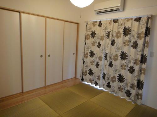 a living room with a curtain and a window at Rental villa Yukura Nakijin near Janglia Okinawa and Churaumi Aquarium in Nakijin