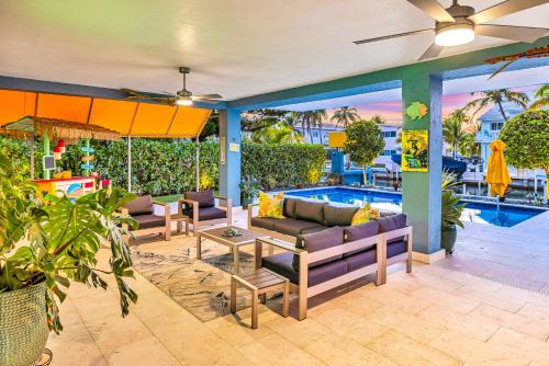 a patio with couches and a swimming pool at Waterfront Covered alfresco lounge Heated Pool Anchor Key in Islamorada