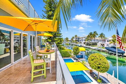 a balcony with a table and chairs and a pool at Waterfront Covered alfresco lounge Heated Pool Anchor Key in Islamorada