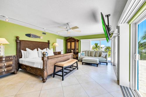 a bedroom with a bed and a couch and a tv at Waterfront Covered alfresco lounge Heated Pool Anchor Key in Islamorada