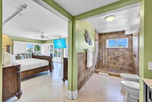 a bathroom with a bed and a shower at Waterfront Covered alfresco lounge Heated Pool Anchor Key in Islamorada
