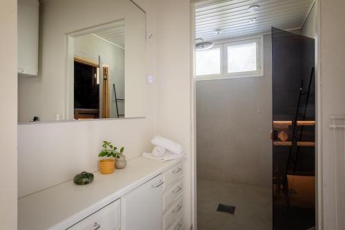 a white bathroom with a sink and a mirror at Stay North - Pohjola in Naantali